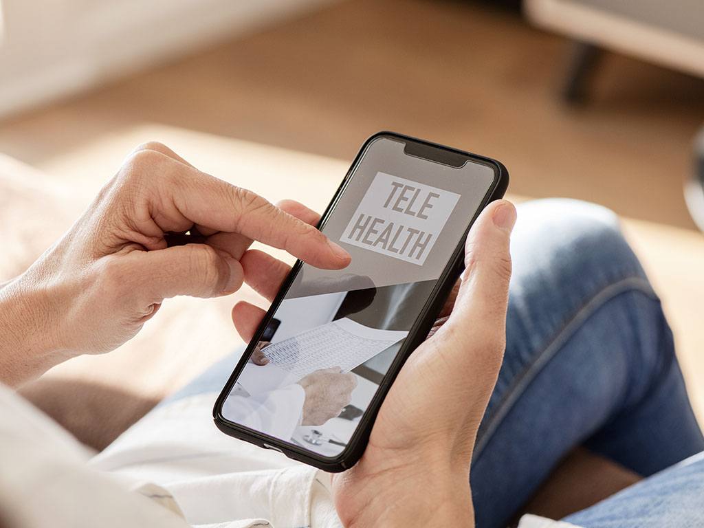 A person using a cell phone to access telehealth therapy or online counseling sessions.