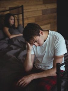 Man sitting on a bed suffering from Seasonal affective disorder depression. Seeing a therapist in Honolulu can help with depression. Wellness Counseling also offers Couples counseling in Honolulu.