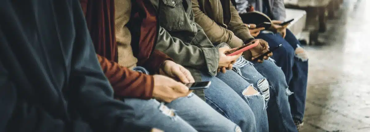 Teens in Hawaii on smartphones. Social media addiction.
