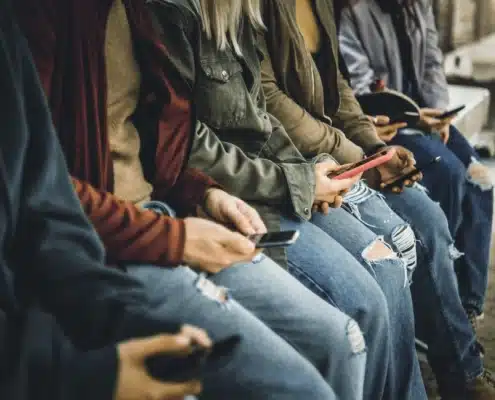 Teens in Hawaii on smartphones. Social media addiction.