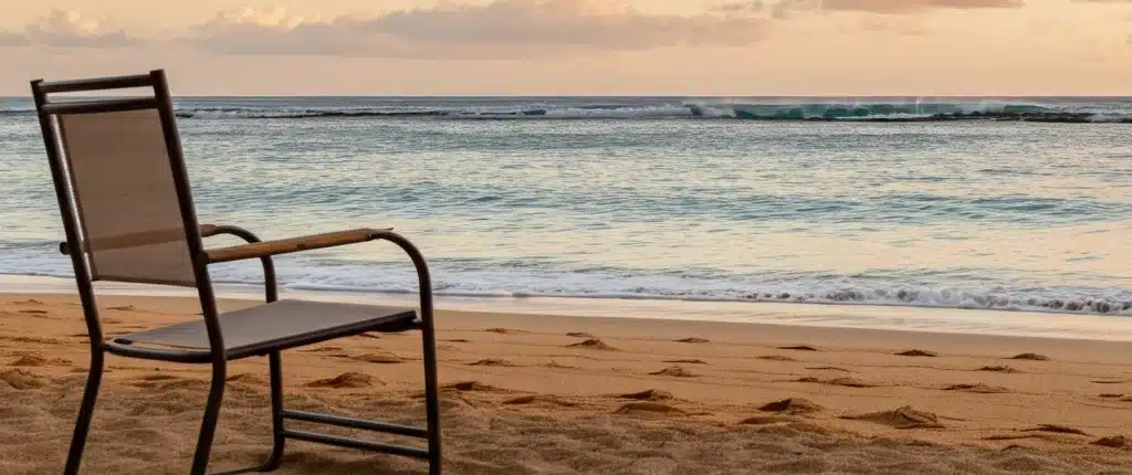 A lone chair at the beach representing the loneliness epidemic in Hawaii caused by social isolation, the erosion of Ohana, and the disconnect caused by social media.