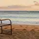 A lone chair at the beach representing the loneliness epidemic in Hawaii caused by social isolation, the erosion of Ohana, and the disconnect caused by social media.