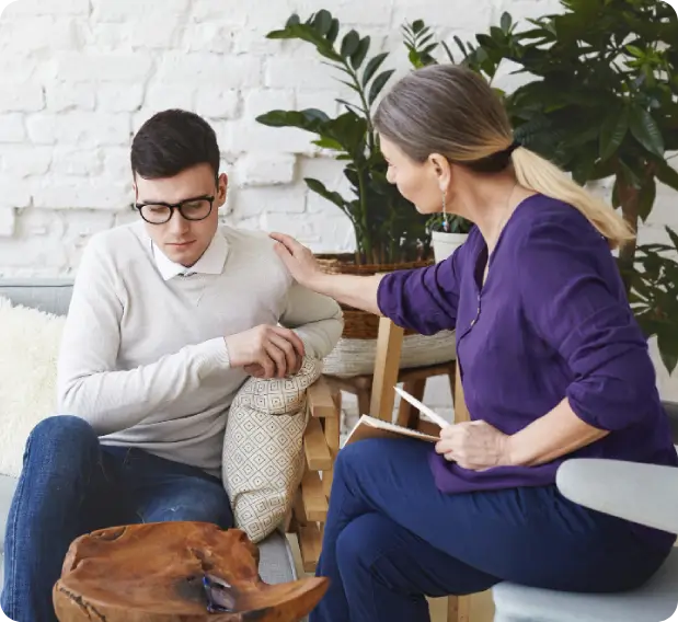 Demonstrating our patient-centered philosophy, a compassionate Kailua therapist places a reassuring hand on a distressed young man’s shoulder during a teen mental health session.